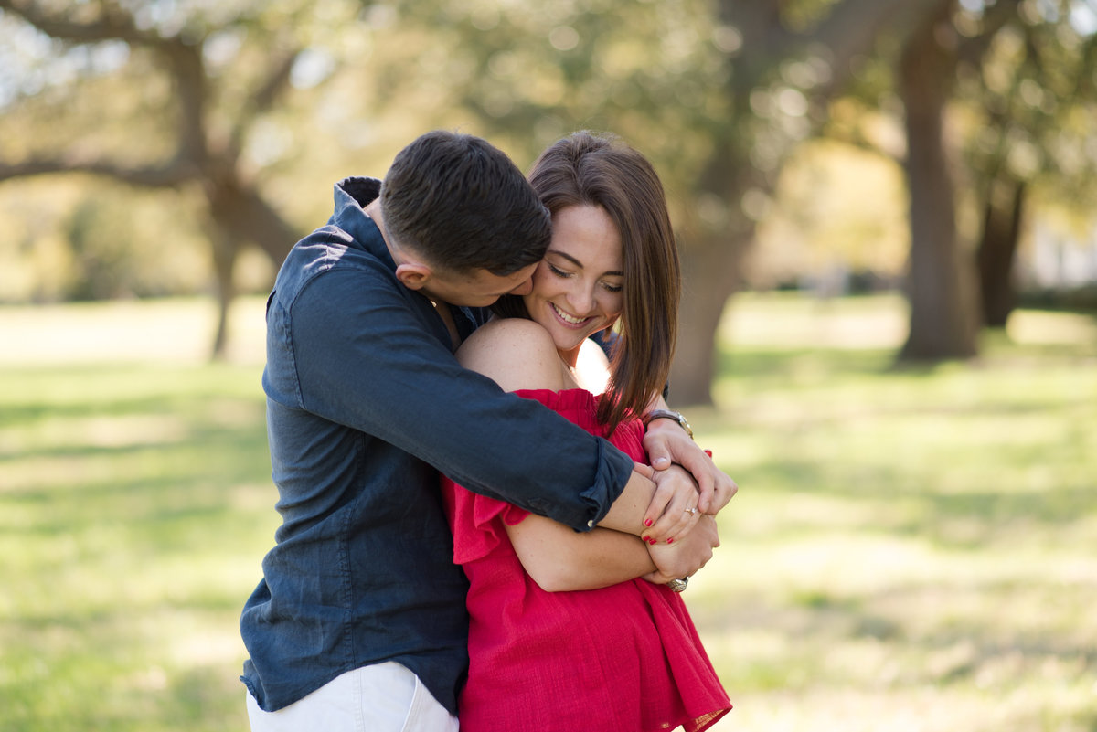 couple cuddling during fort monroe engagement session by hampton virginia photographer