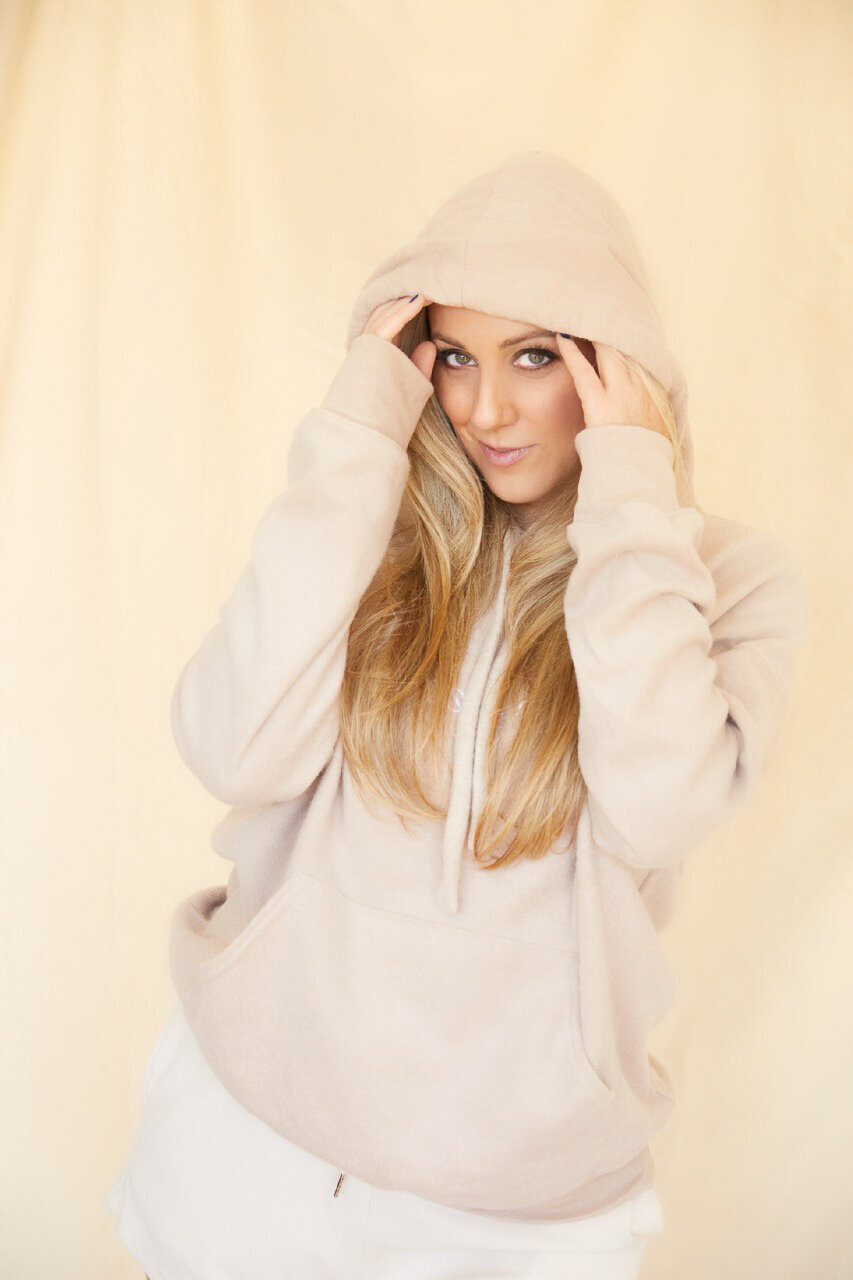 Georgiana is wearing the oatmeal Chaos & Calm fleece hoodie in merch shoppe