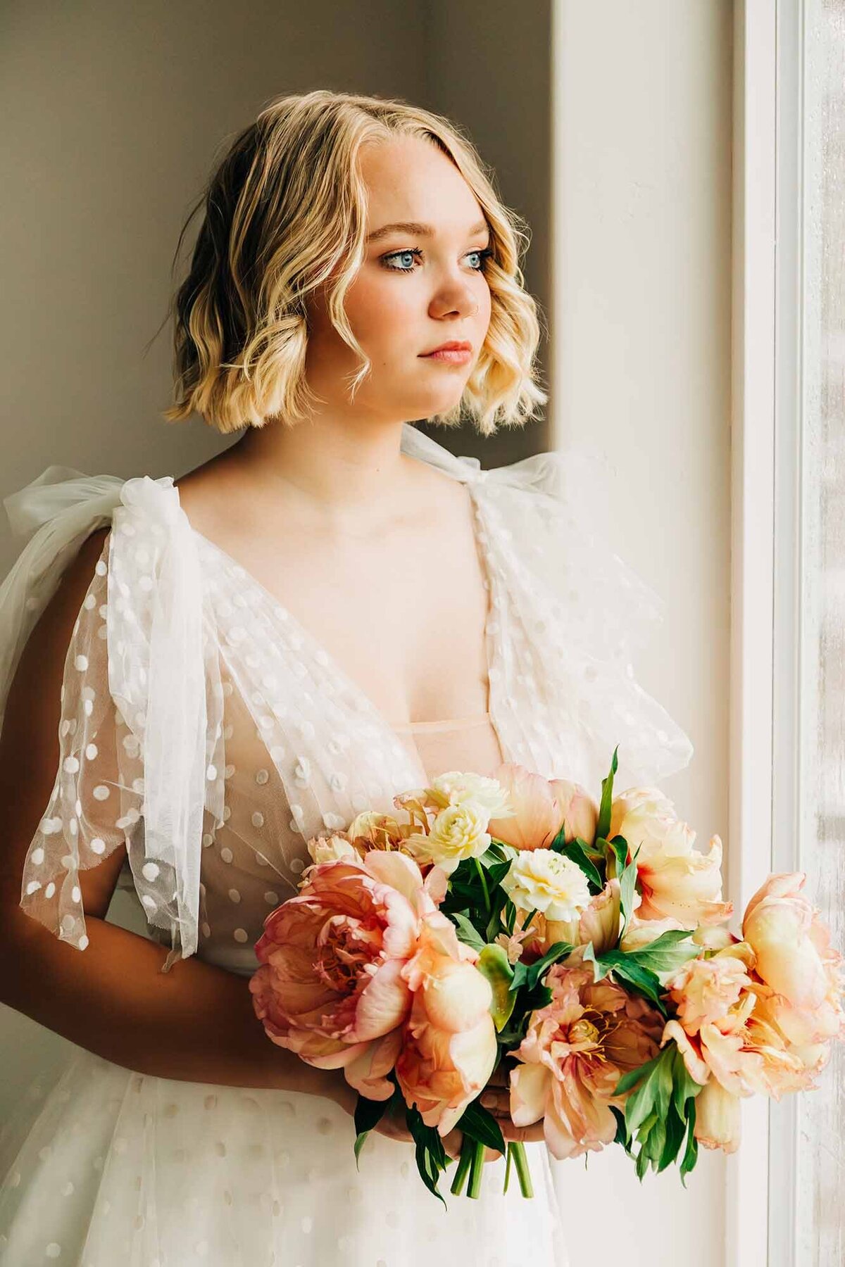 Montana bride holding bouquet looking out window, Corvallis, MT