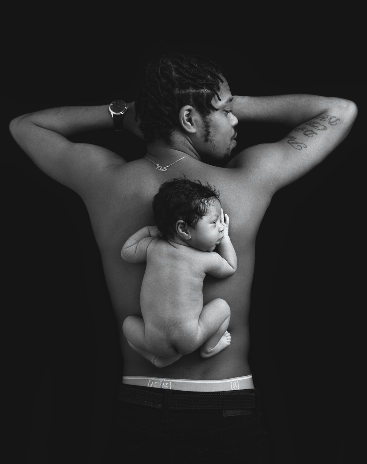 dupont newborn baby boy and dad lying on belly pose on black and white near dupont