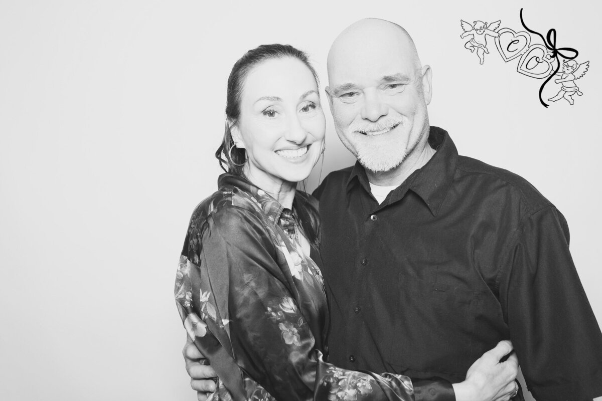 A couple embrace and smile and the camera, representing an image taken by the Birdie Booth an Eugene photo booth rental.