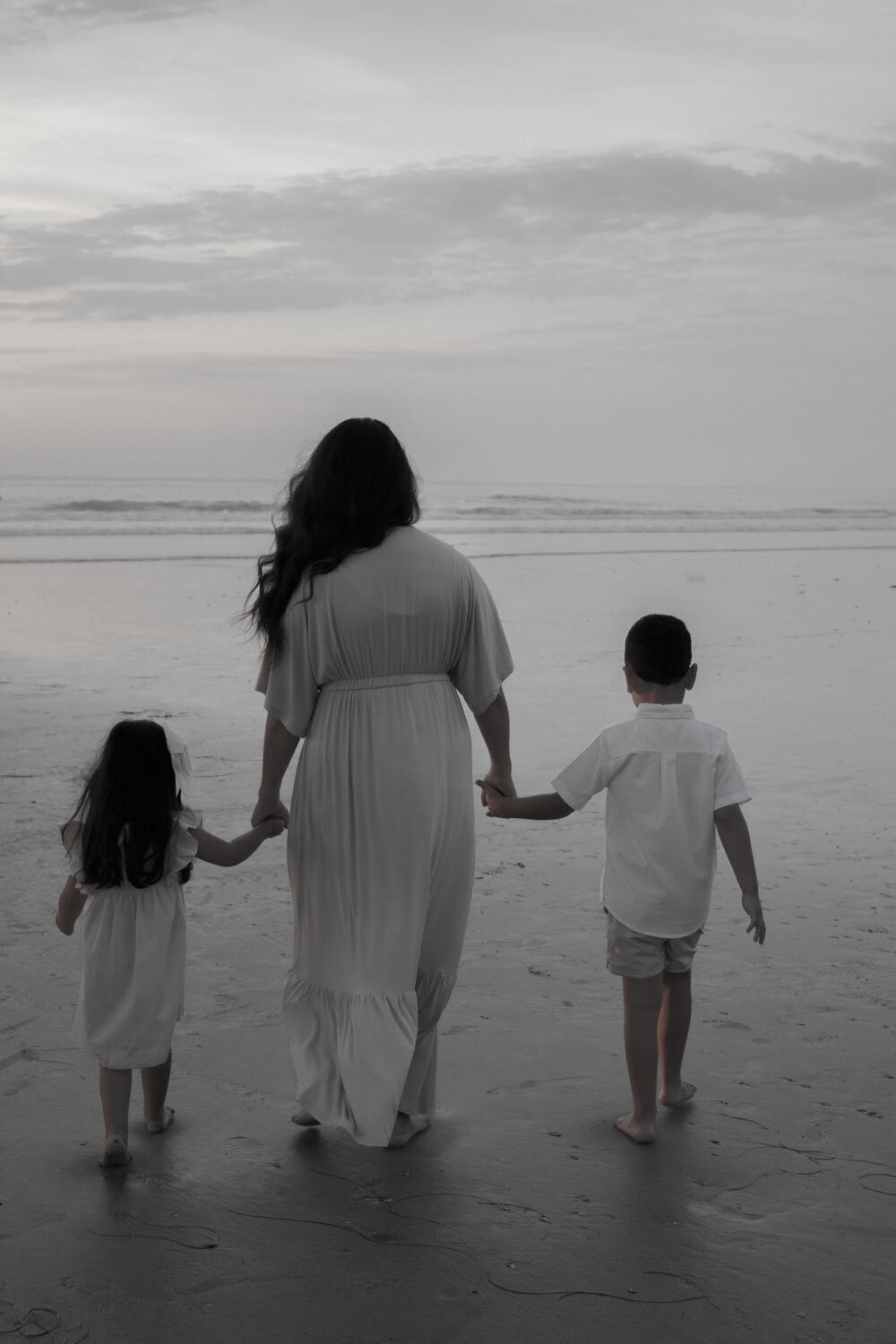 Family walking along the beach at sunset