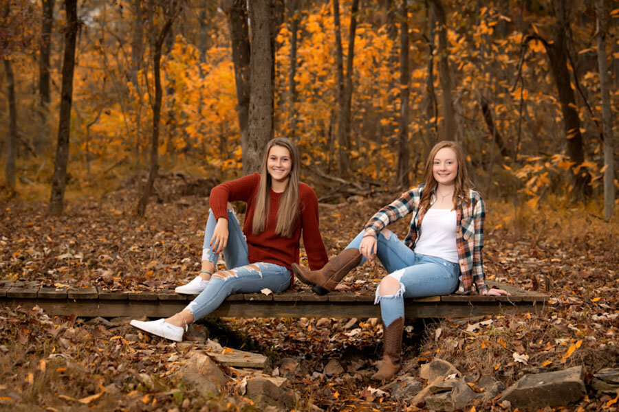 senior girl and friend in fall leaves
