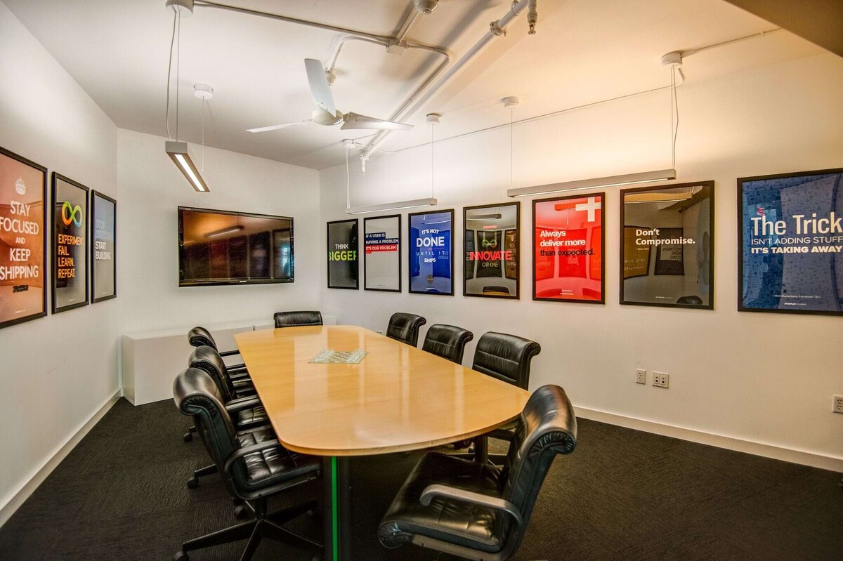 Small conference room with 8 black chairs