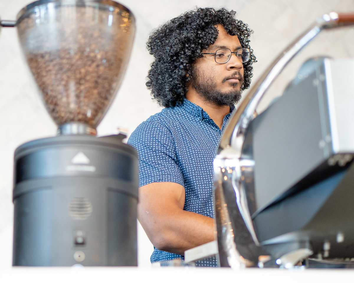 Man making coffee behind an espresso machine in Flower Mound