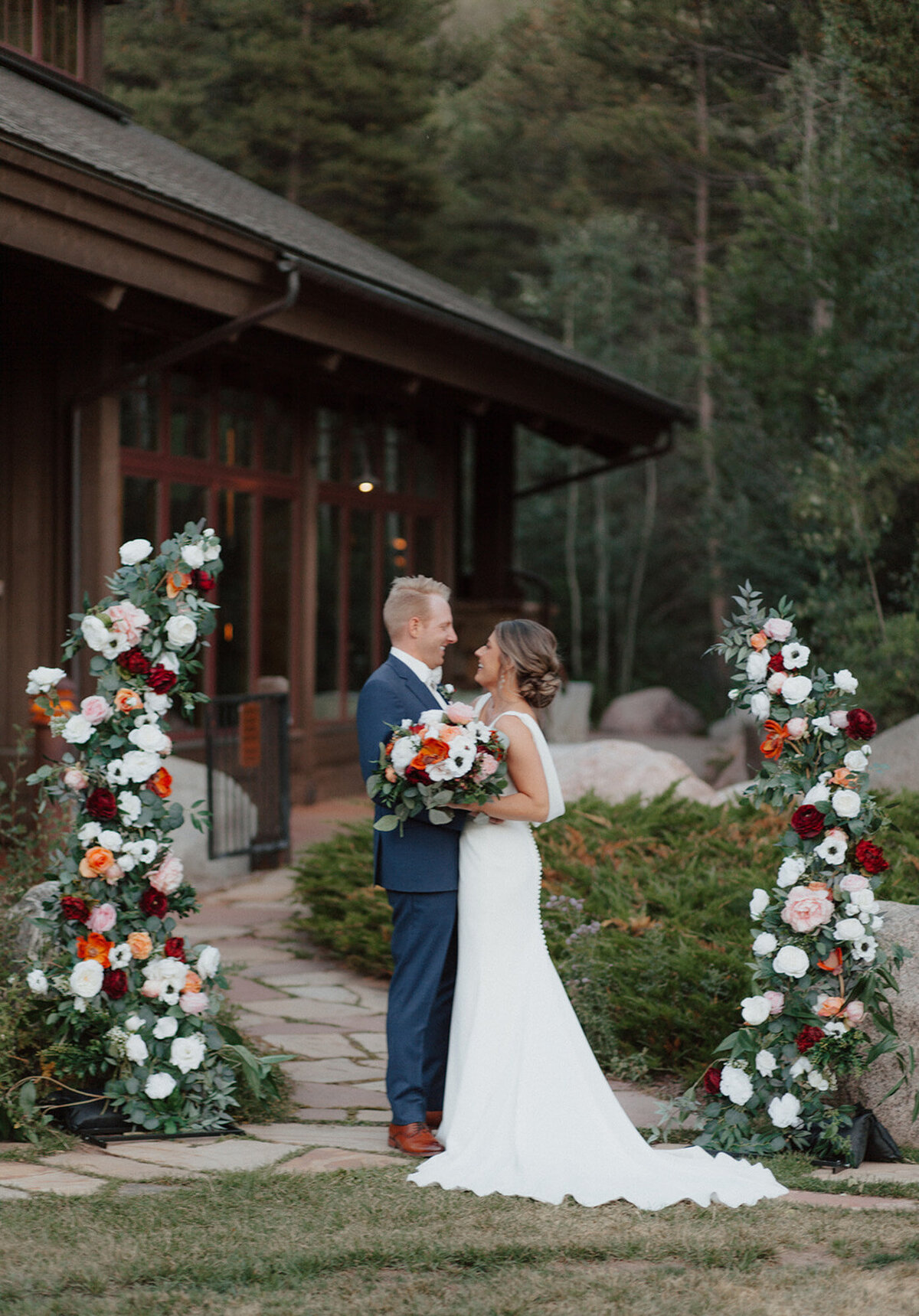 Alana and Ryan on their wedding day and their elegant wedding floral backdrop