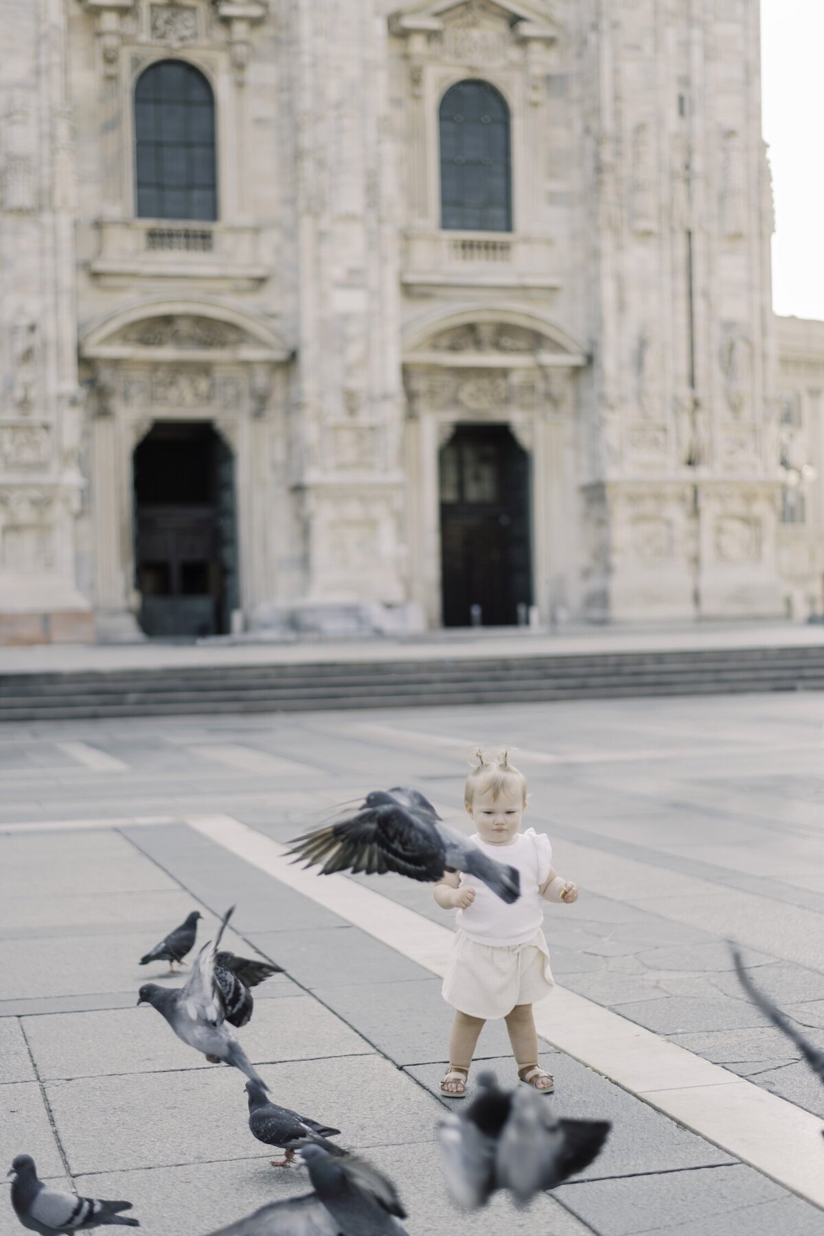 child joyfully playing near the Duomo di Milano during a family session

