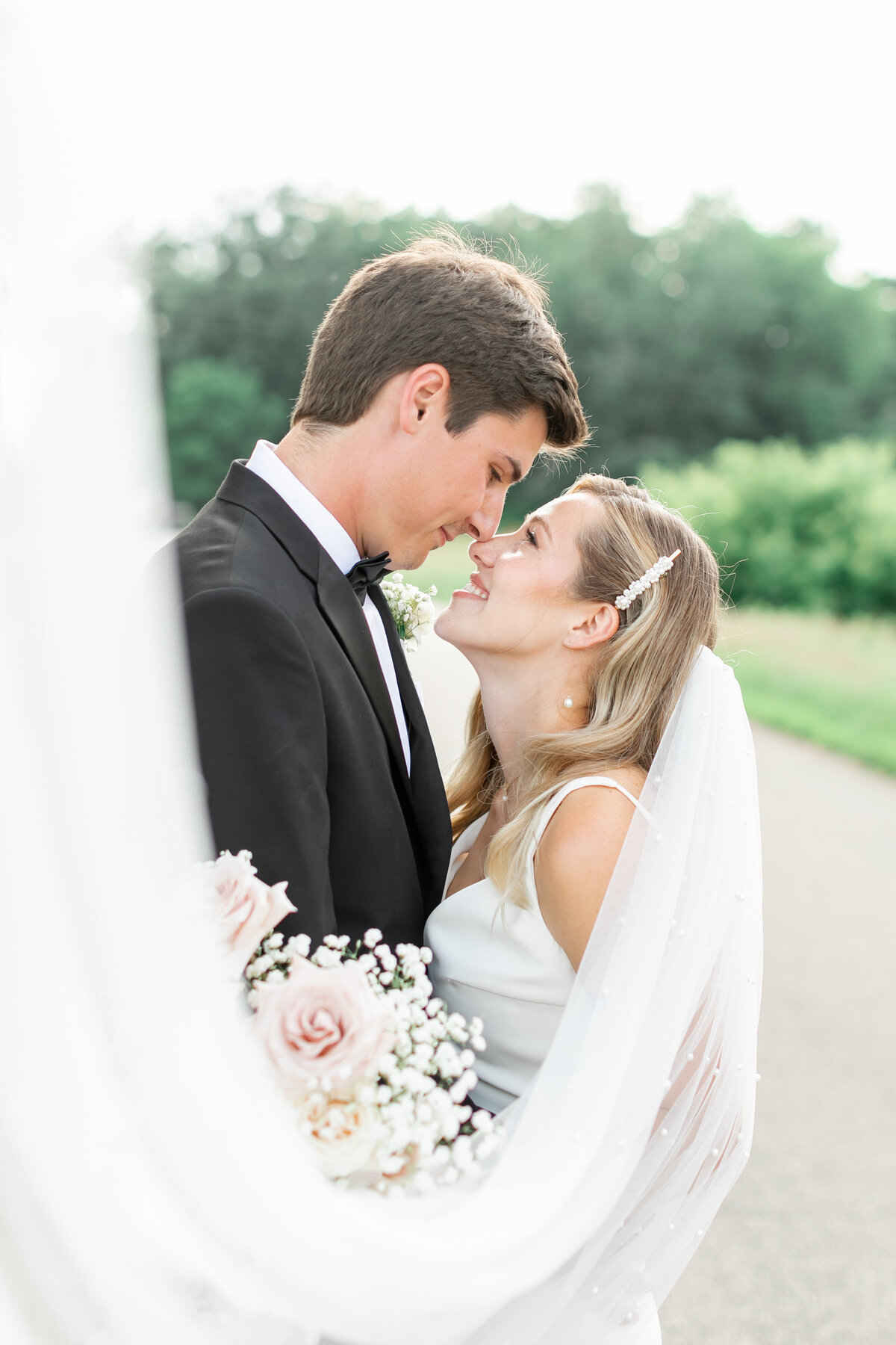 couple smiling at each other and their veil in front by wedding photographers orlando