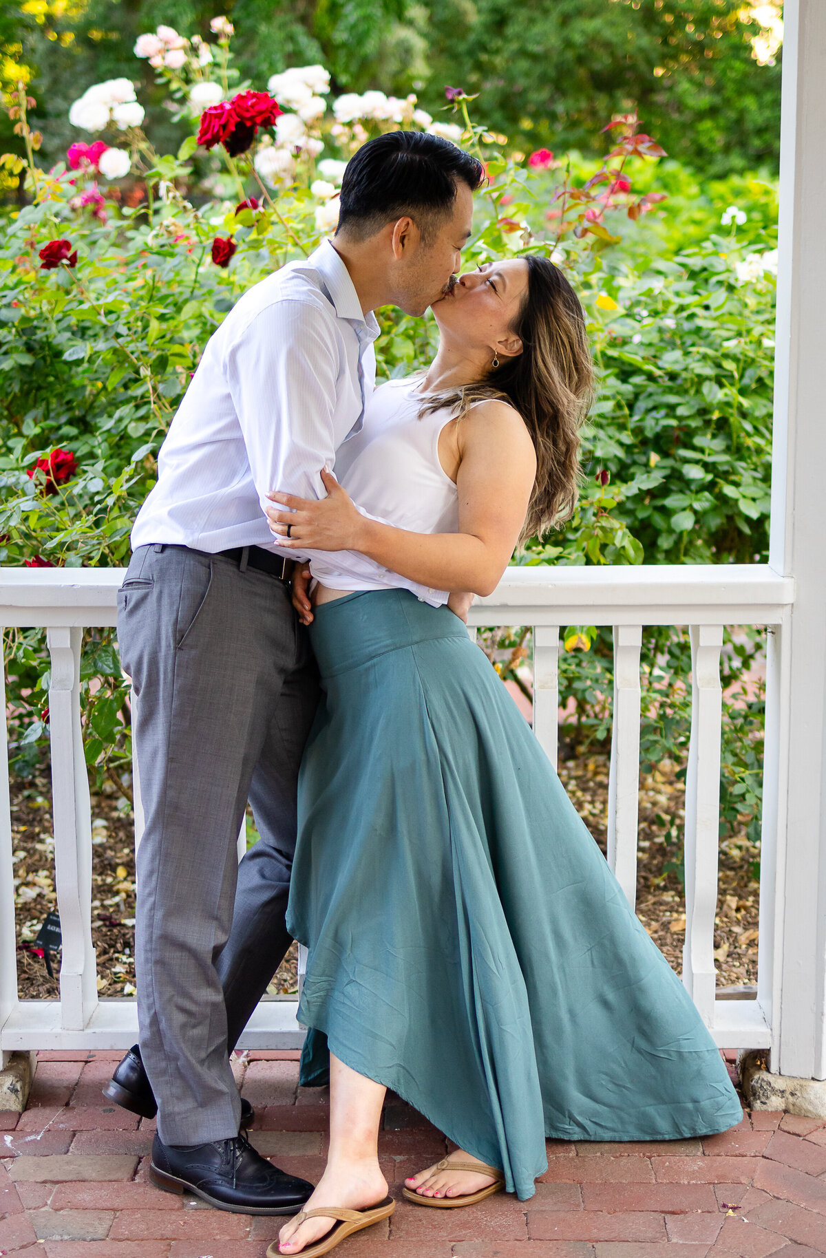 A joyful couple's portrait session in a blooming garden during golden hour