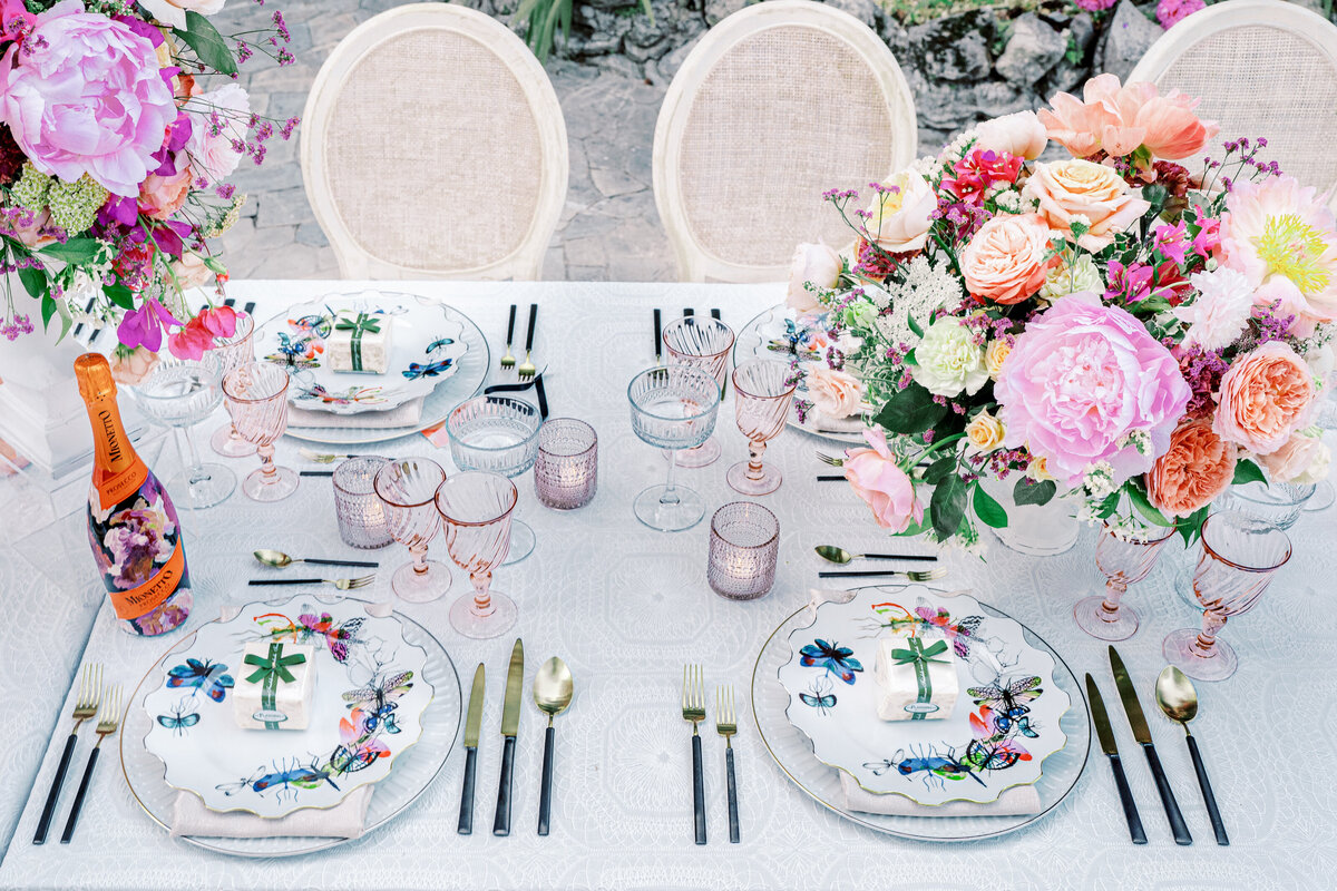 Lake Como Italy wedding reception table full of vibrant colored, oversized flowers photographed by Lake Como Wedding photographer