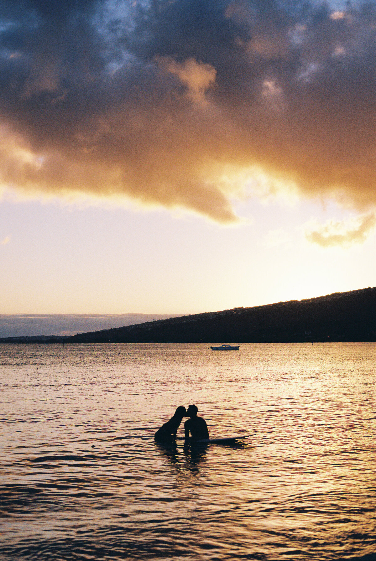 silhouette-of-kissing-couple-on-surfboards