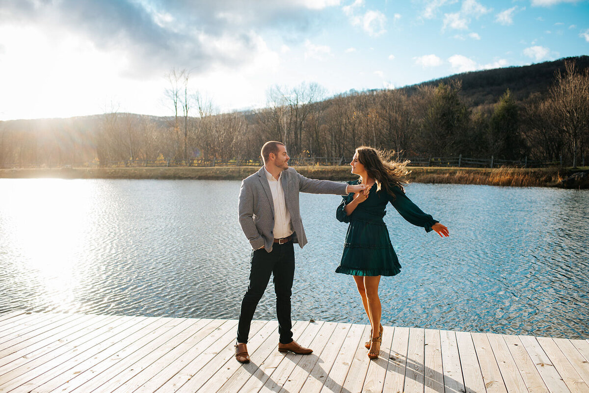 engaged couple dancing on dock at ponds at bolton valley equinox