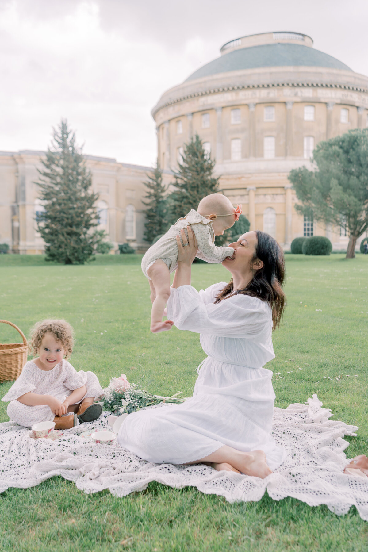 Mother plays with her little baby at an outdoor tea party by Savannah Family Photographer Courtney Cronin