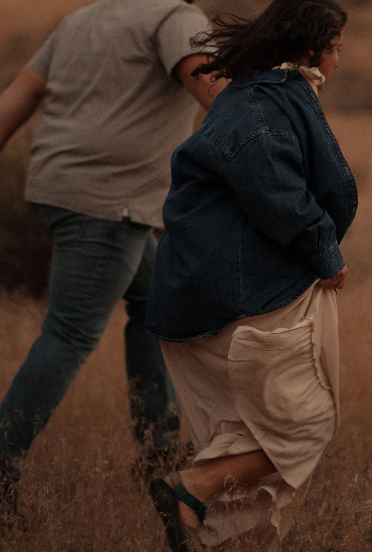 a couple run through the tall grasses after they eloped in the Moab, Utah desert 