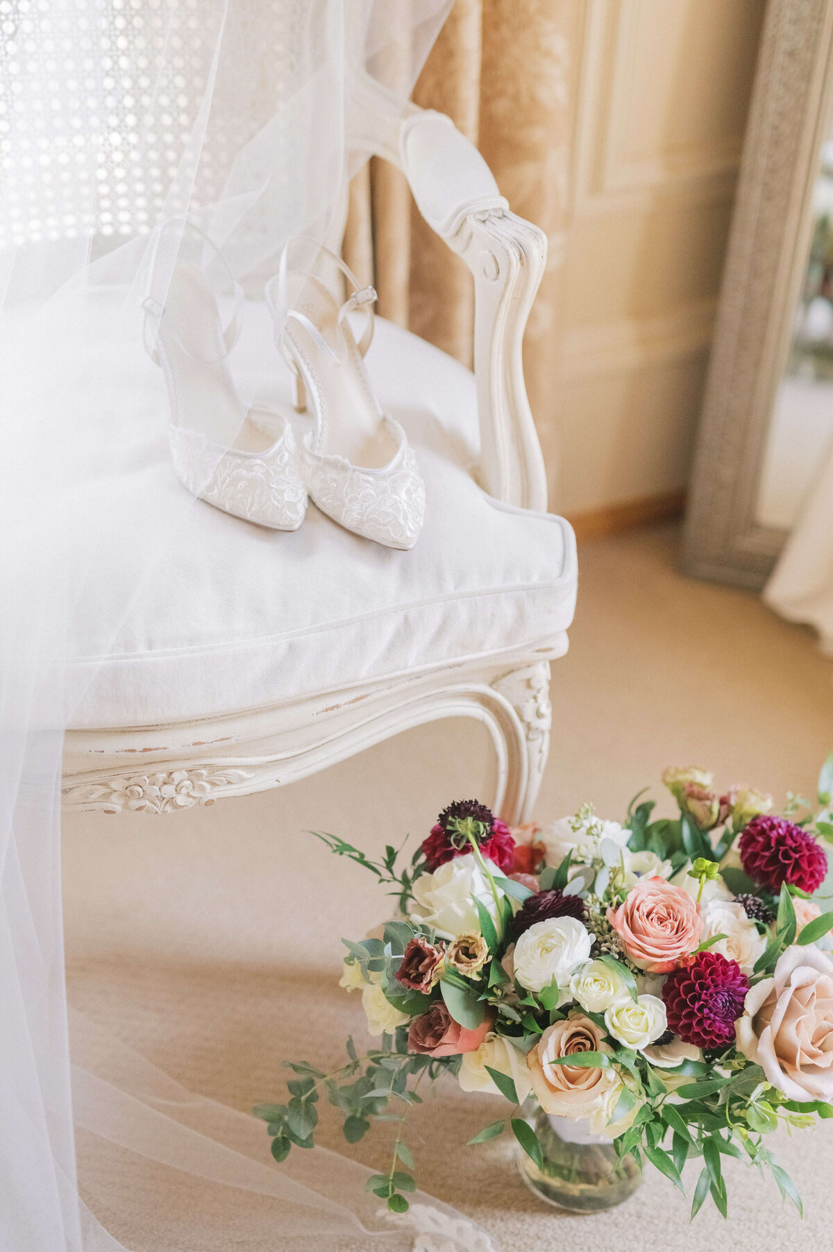 Bella Belle wedding shoes sitting on chair with bouquet styled for wedding photography by Rachael Mattio