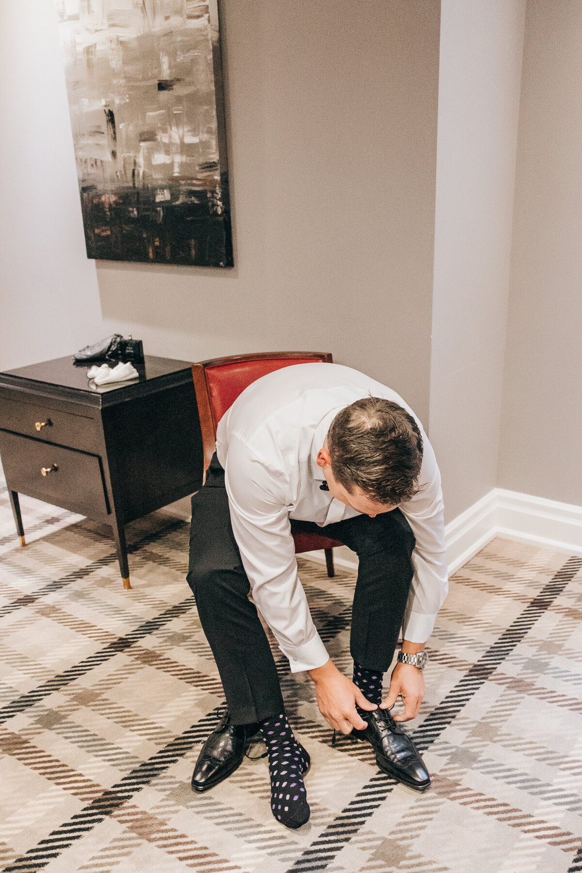 A groom tying his wedding day shoes