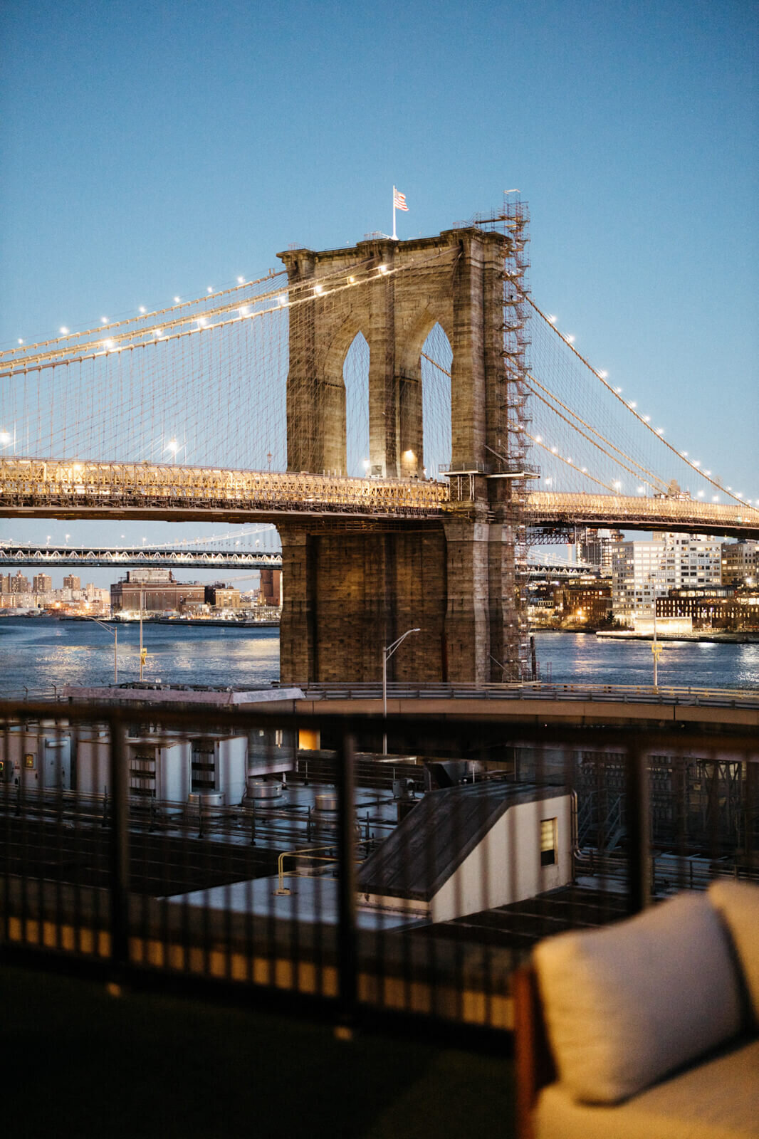 A view of the Brooklyn Bridge with the lights on.