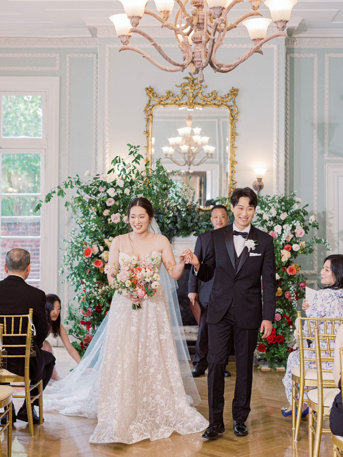 Couple walking down aisle, smiling after ceremony