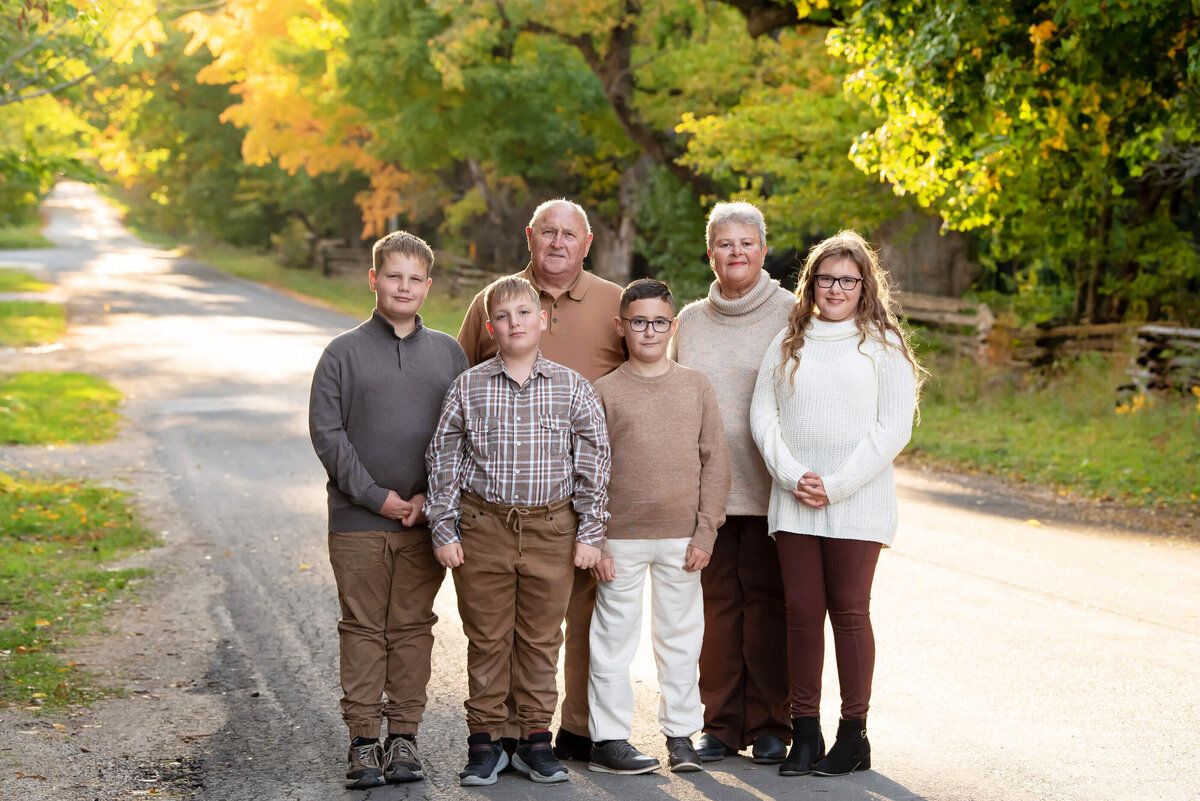 Grandparents with their 4 grandchildren, 3 boys and a girl for their fall family photography session in Burlington