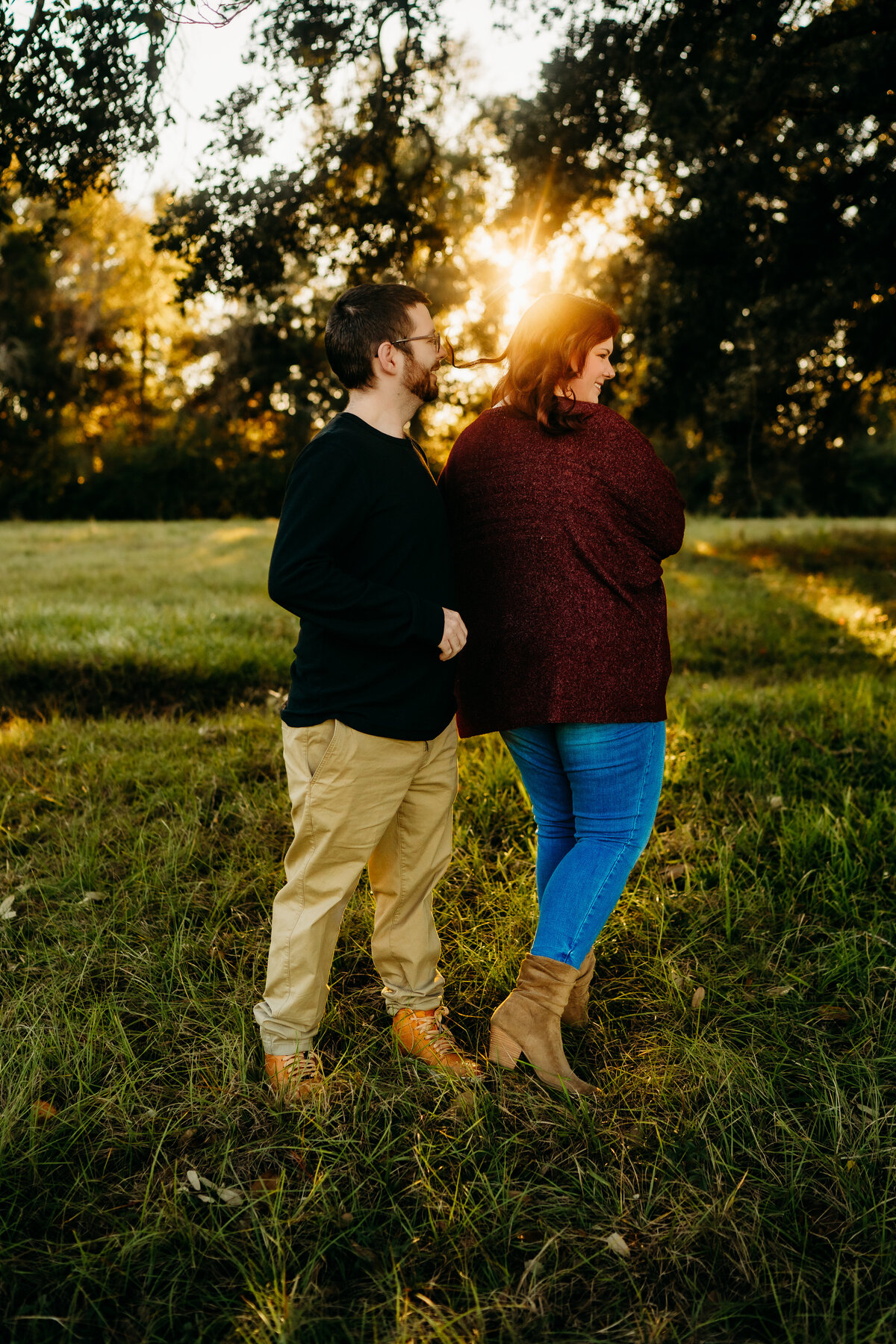 candid engagement photo of couple dancing at sunset in field in Lafayette, la