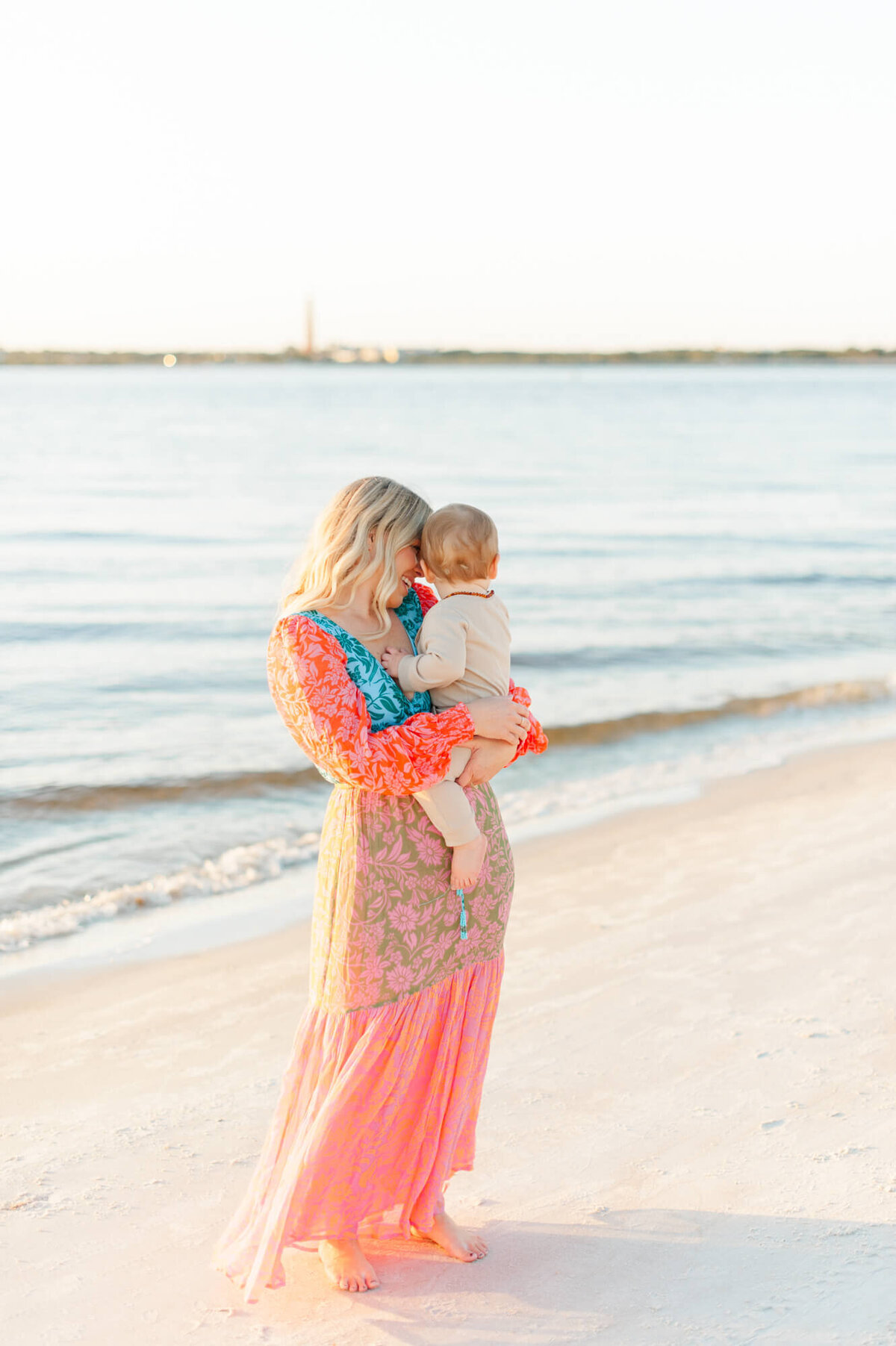 Mom standing near the shoreline embracing her son  near the shoreline