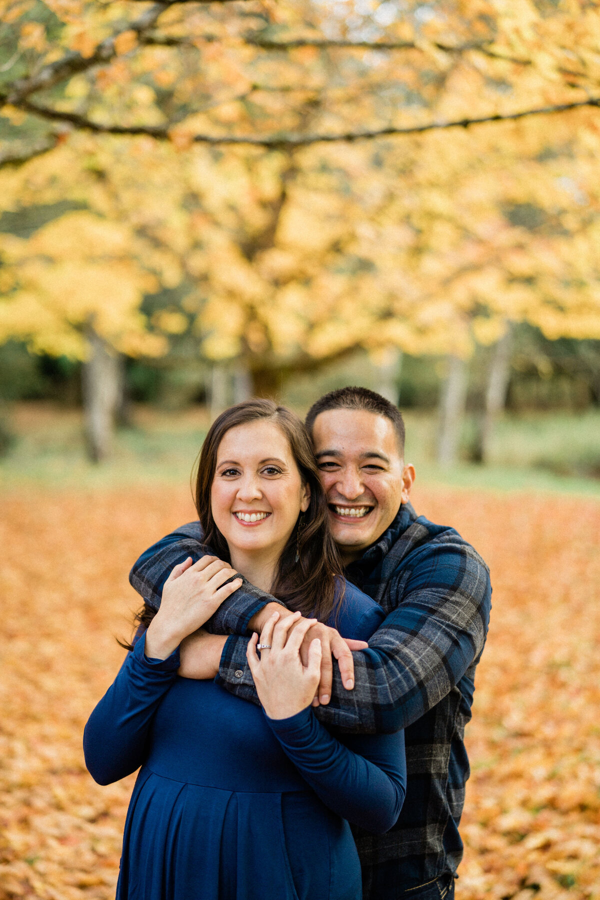 Couple hugging at Rockwood Farm, the best place for engagement photos in Seattle during fall color season