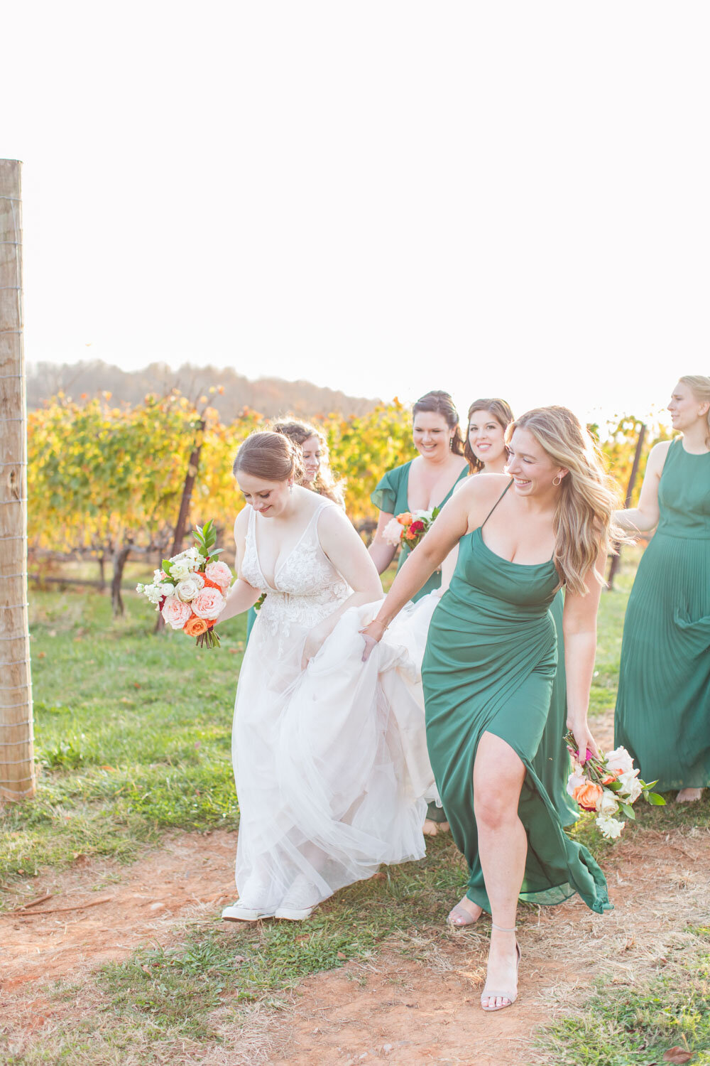 Bride and bridesmaids walking outside in the greenery venue