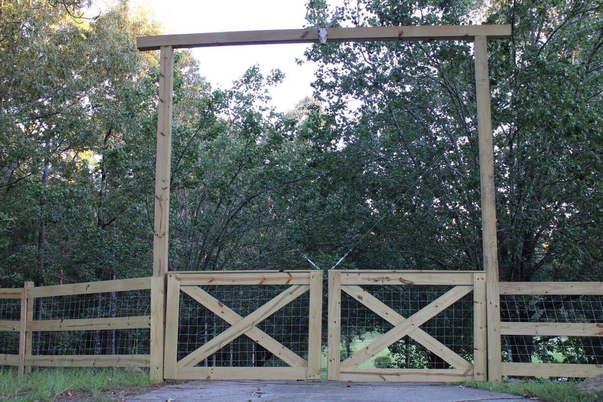 tall-wooden-gate-with-two-doors-and-cow-head-centerpiece