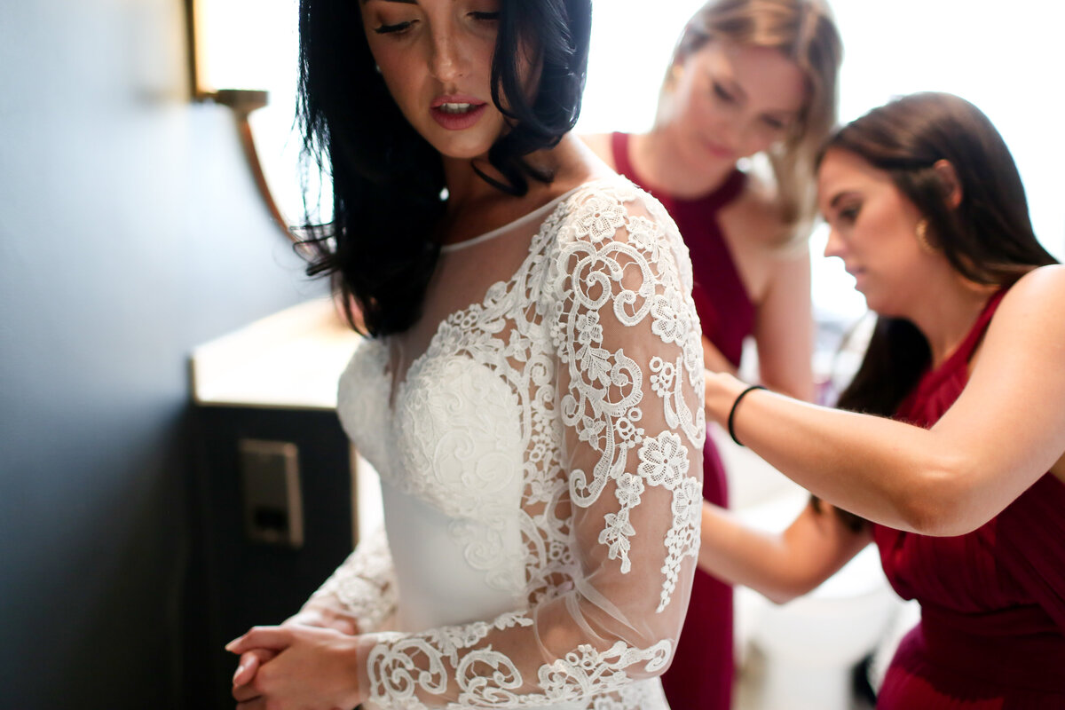 bridesmaid-does-up-brides-dress-at-luxury-wedding-in-belgravia