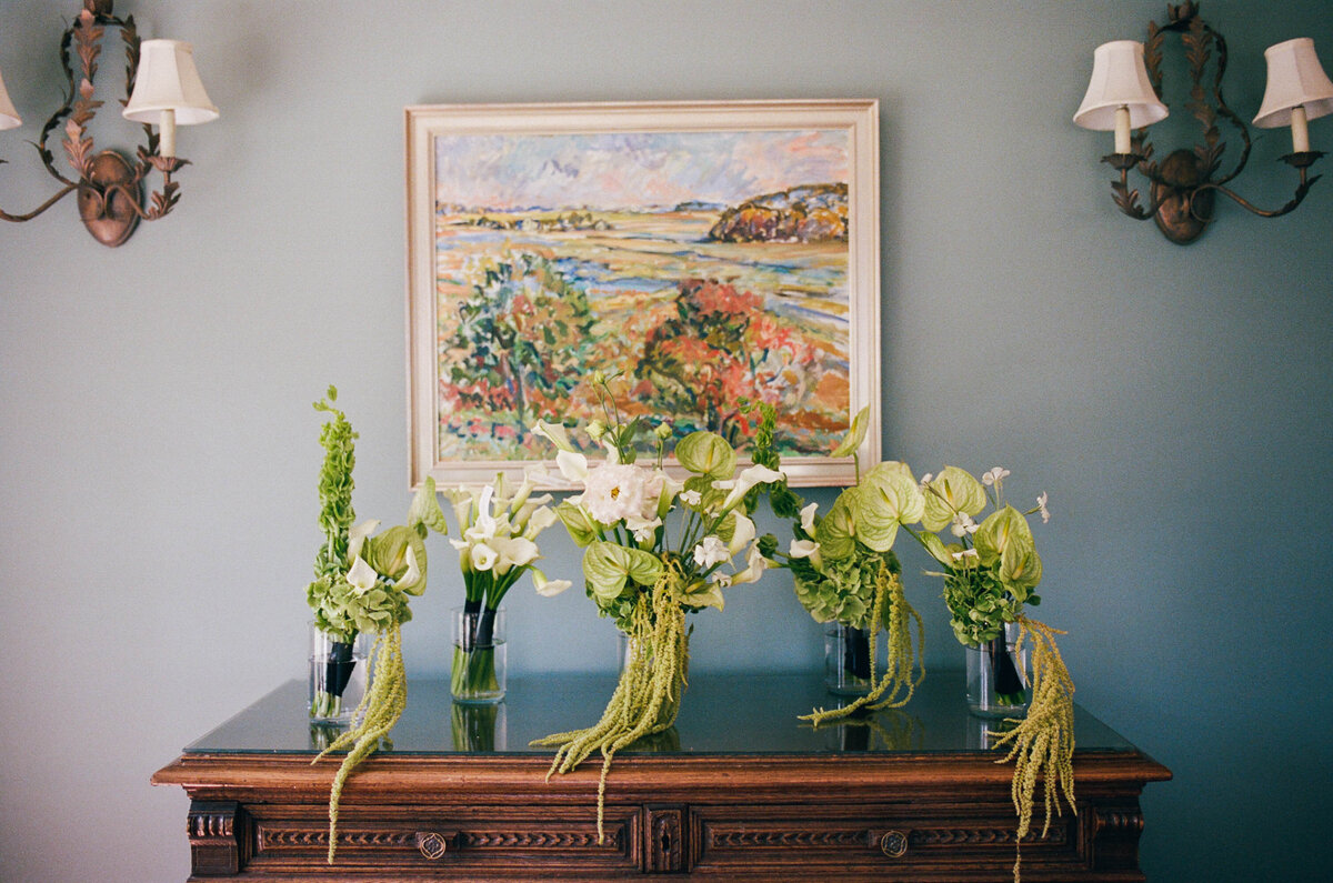 green and white bridal and bridesmaids bouqets lined up on shelf taken by boston documentary wedding photographer