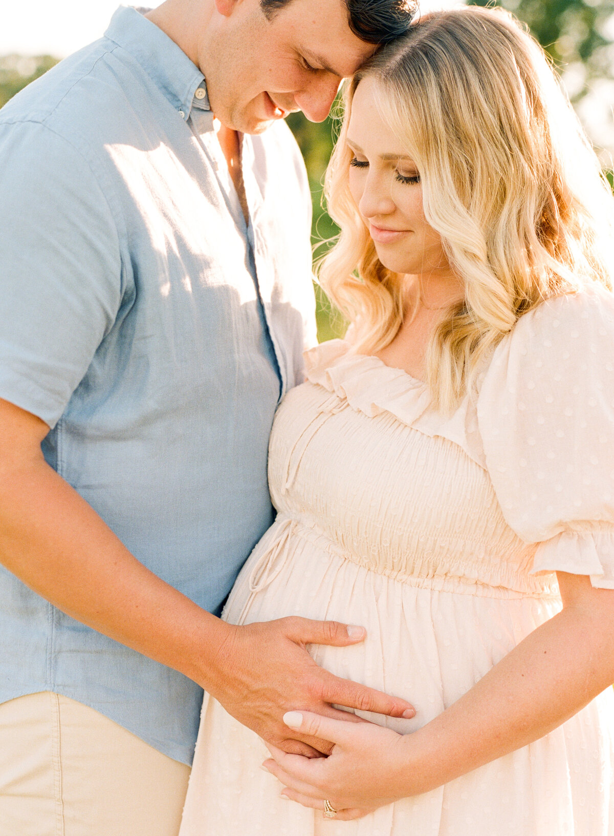 New parents touch expectant belly. Image by Raleigh maternity photographer A.J. Dunlap Photography.