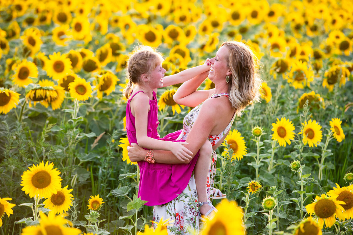 Ottawa family photography of a mom and daughter playing in a filed of sunflowers at sunset