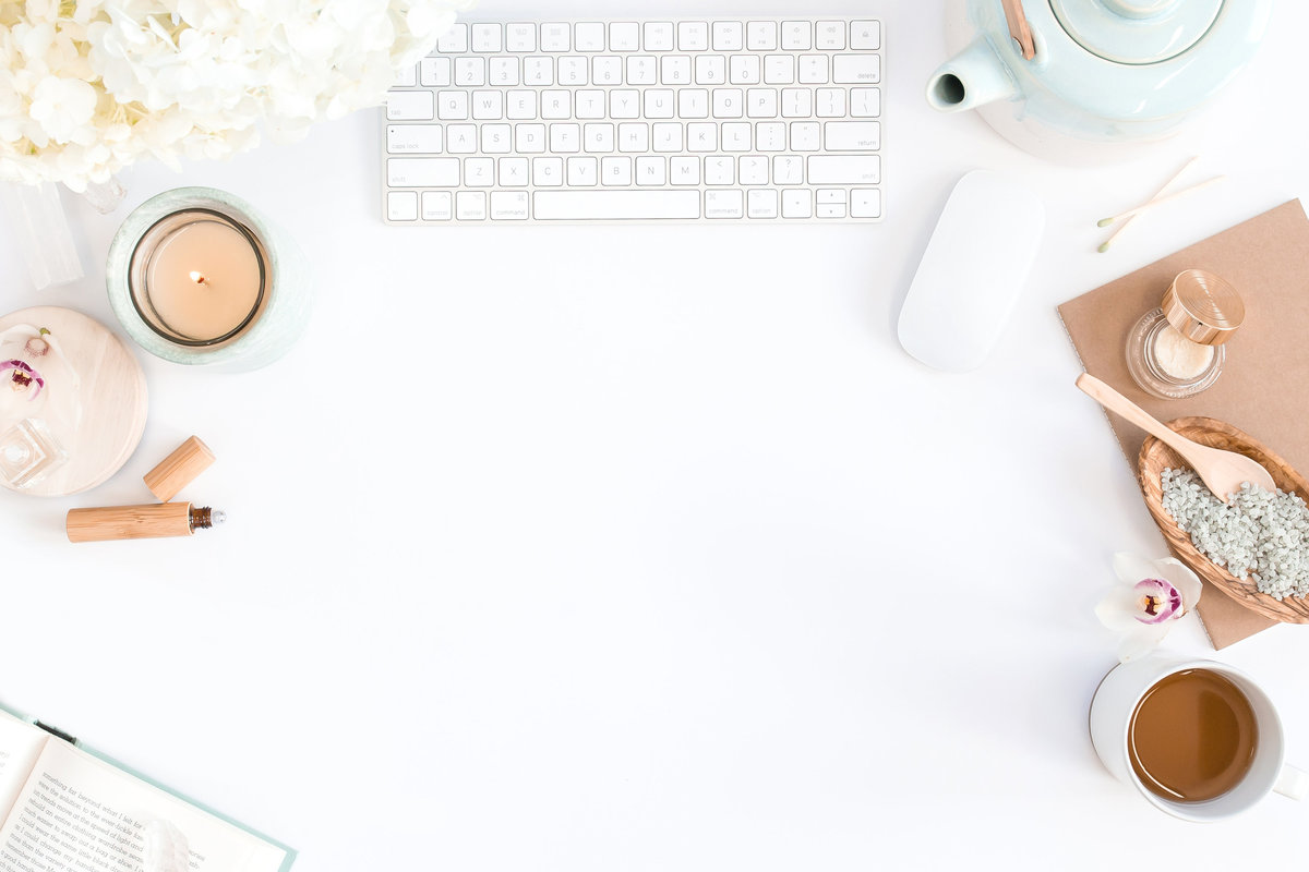 Relaxing desktop with tea, candle, essential oils, and calming workspace accessories for self-care and creativity.