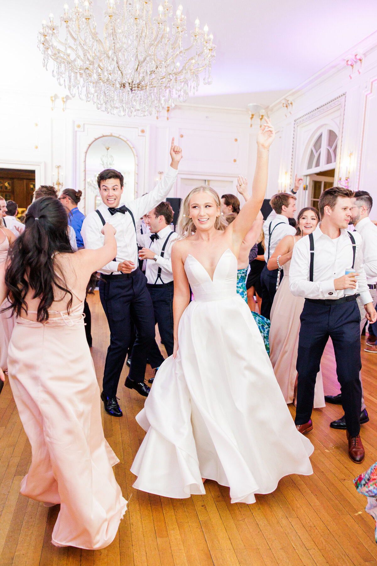 Bride dancing with friends representing joyful wedding services in Boston