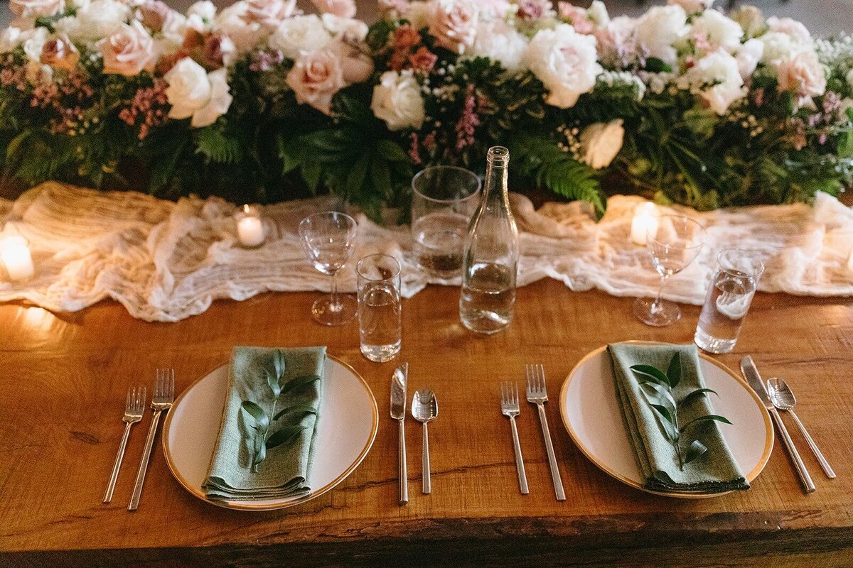 Table settings and floral garland along reception table at wedding at Maysara winery.