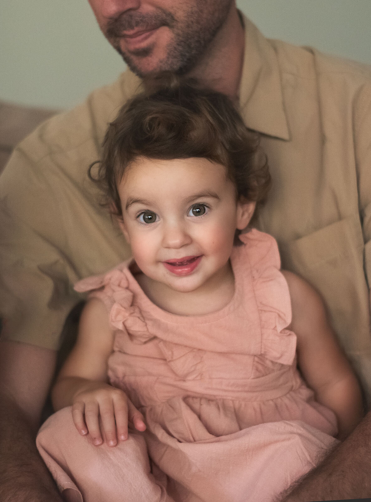 girl on dads lap looking at camera by st. louis family photography, sutherland photography