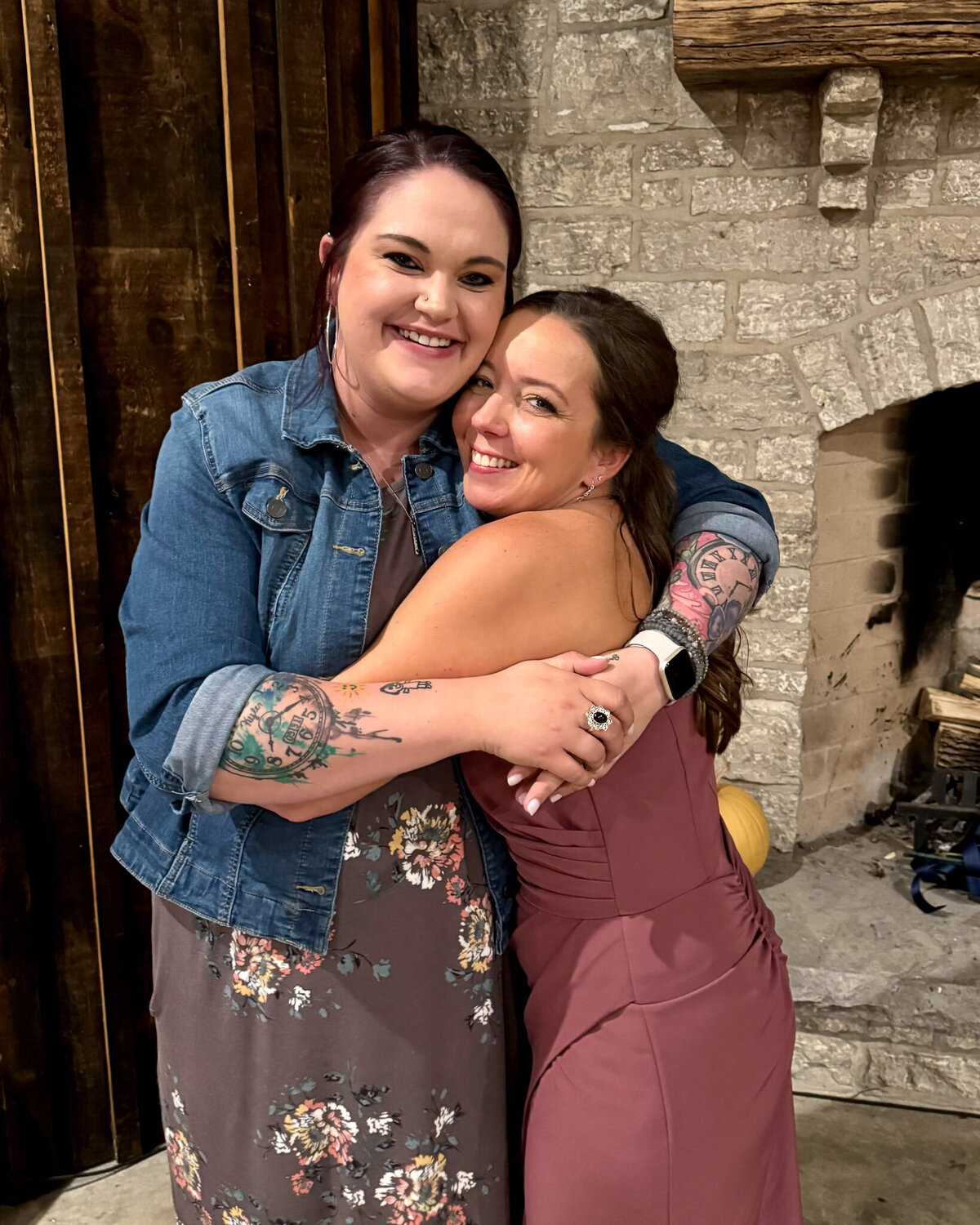 two best friends hugging at a wedding, looking at the camera smiling