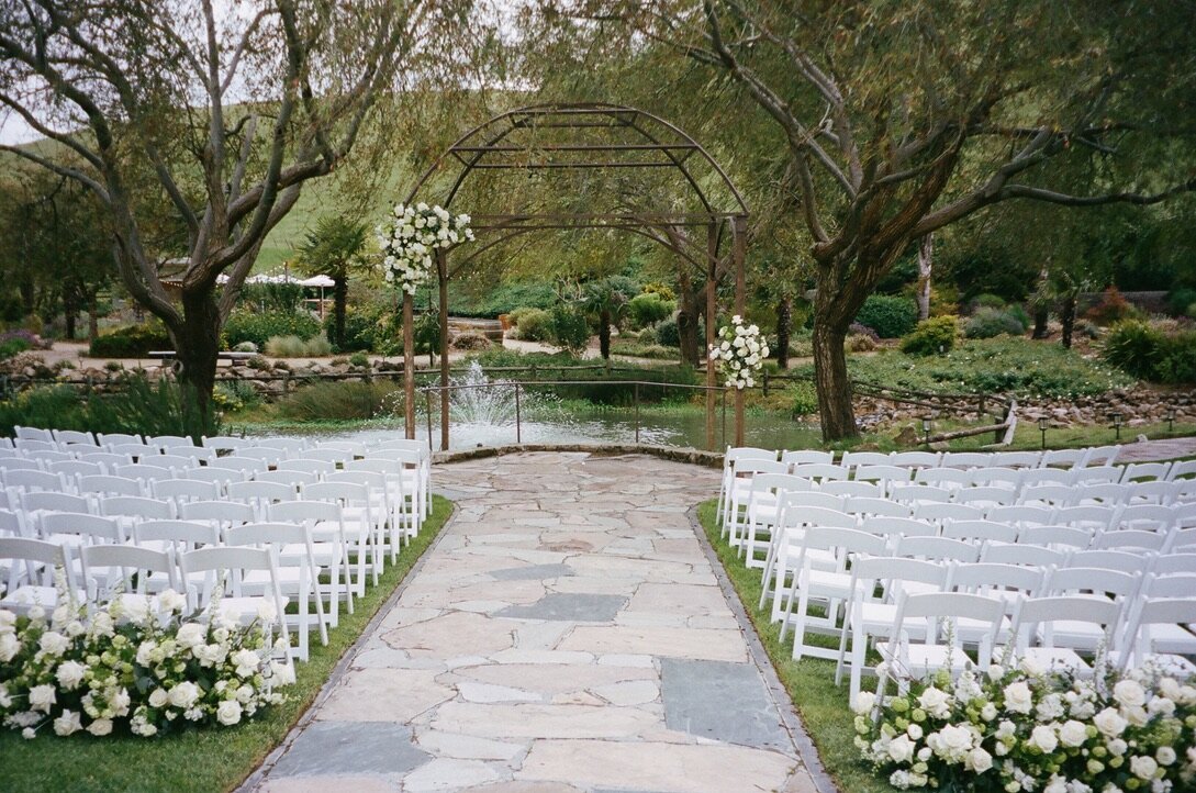 Left corner and right tieback, wedding altar, arch, beginning of aisle arrangements, white and green flowers
