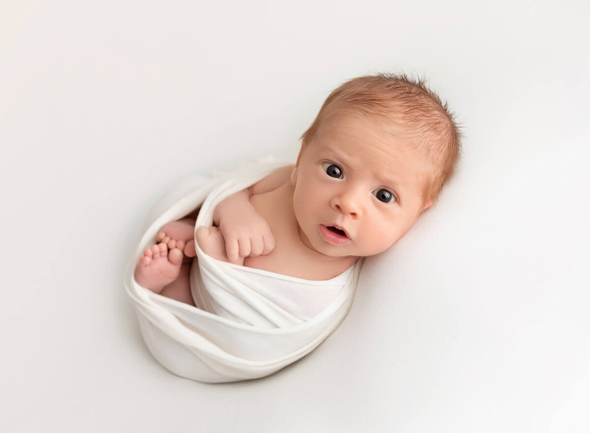 awake baby boy during a newborn  session take by NYC newborn photographer