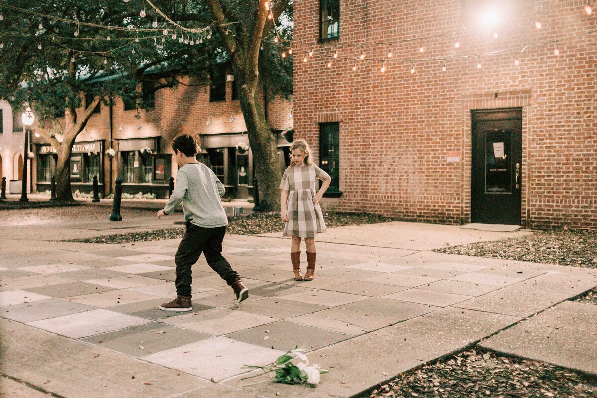 brother and sister play large chess game for houston family photographer