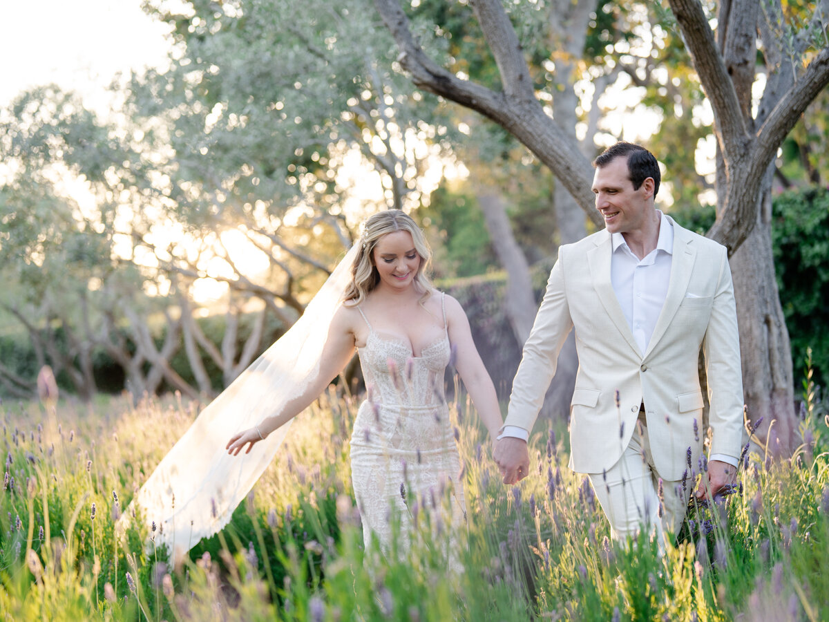 Bride and groom walking in lavender field