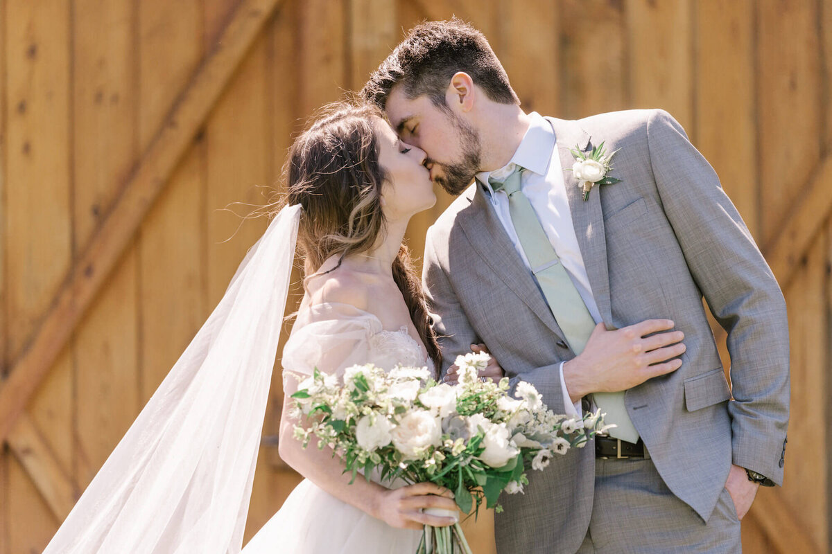 Christina and Bob wedding - couple kissing with flowers