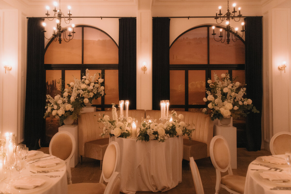 An intimate sweetheart table at the Atwater Club decorated with candles and white flowers.