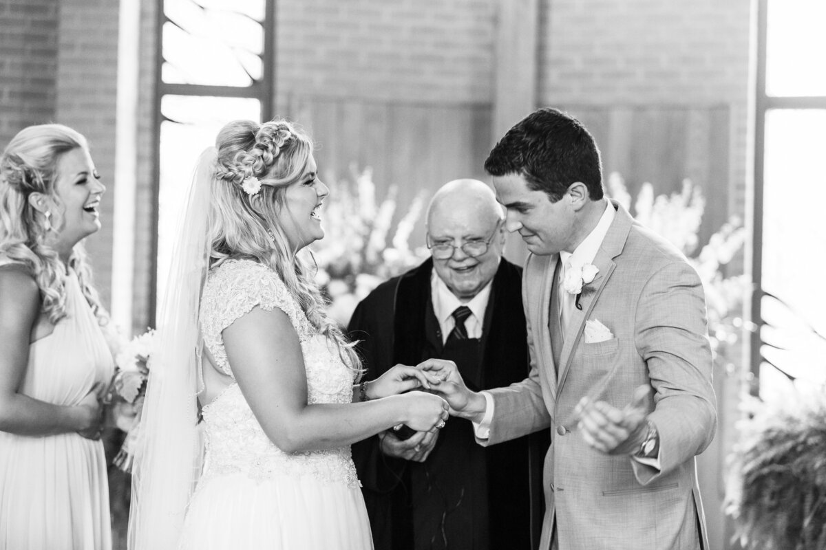 A candid moment of a bride and groom exchanging rings during a church ceremony.