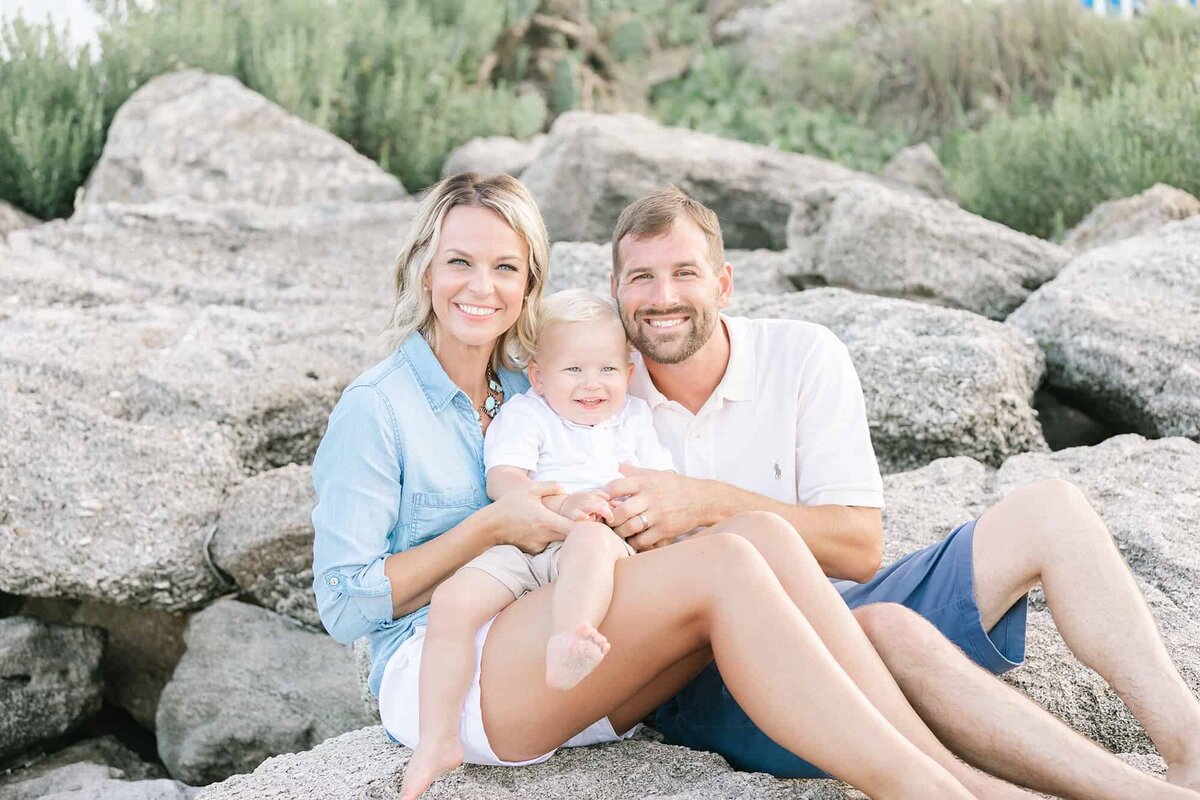 Parents sitting on rocks with a little boy