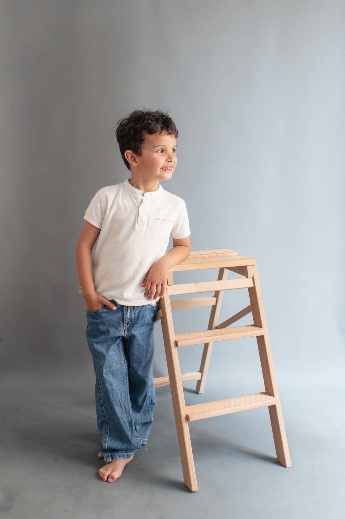 Enfant accoudé à un tabouret, dans un appartement parisien