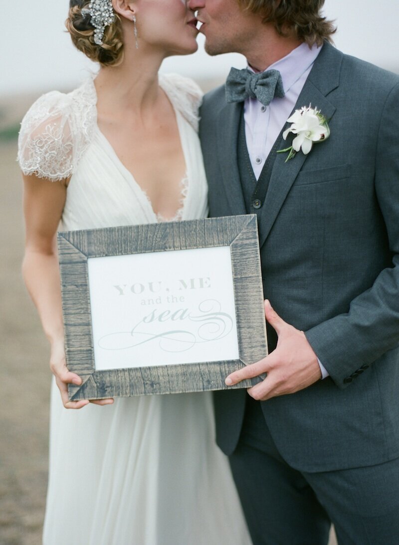 bride and groom hold a sign