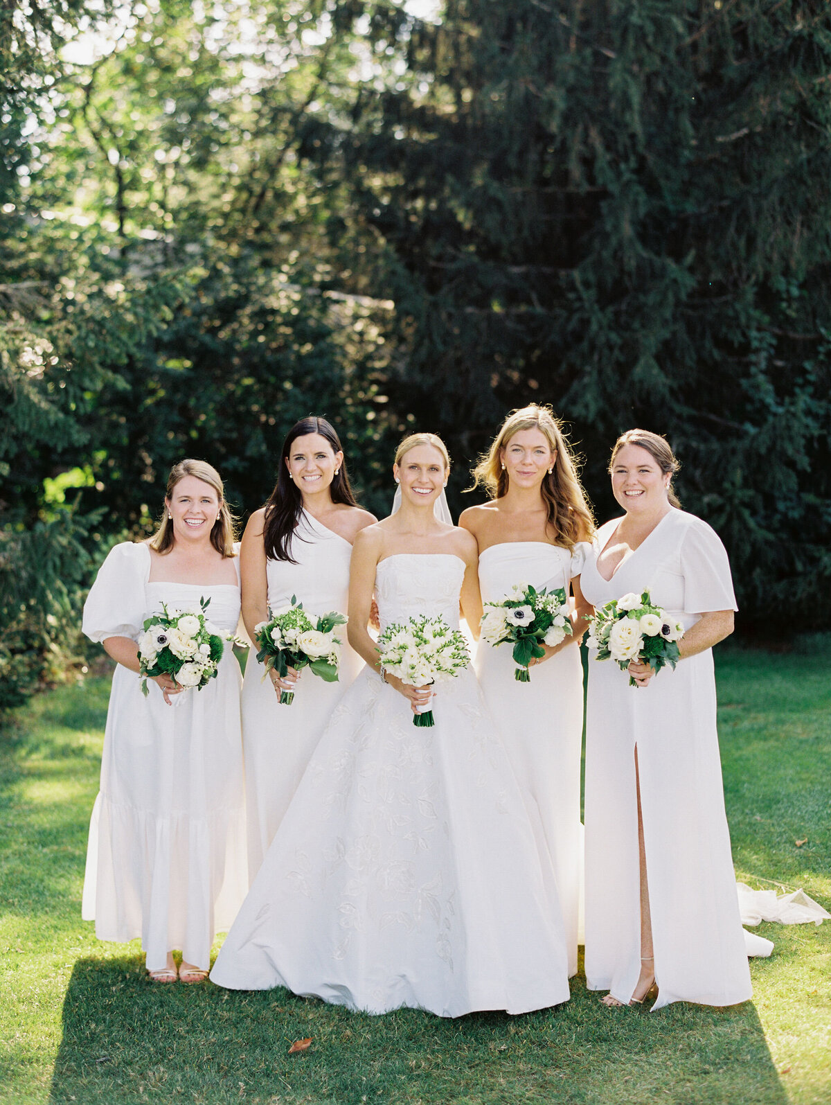 A group photo of the bride and bridesmaid on a sunny day. 