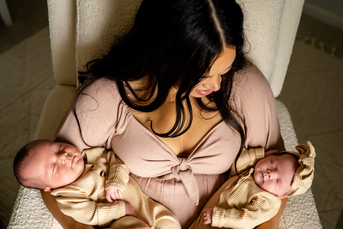 Mother holding twin newborn babies