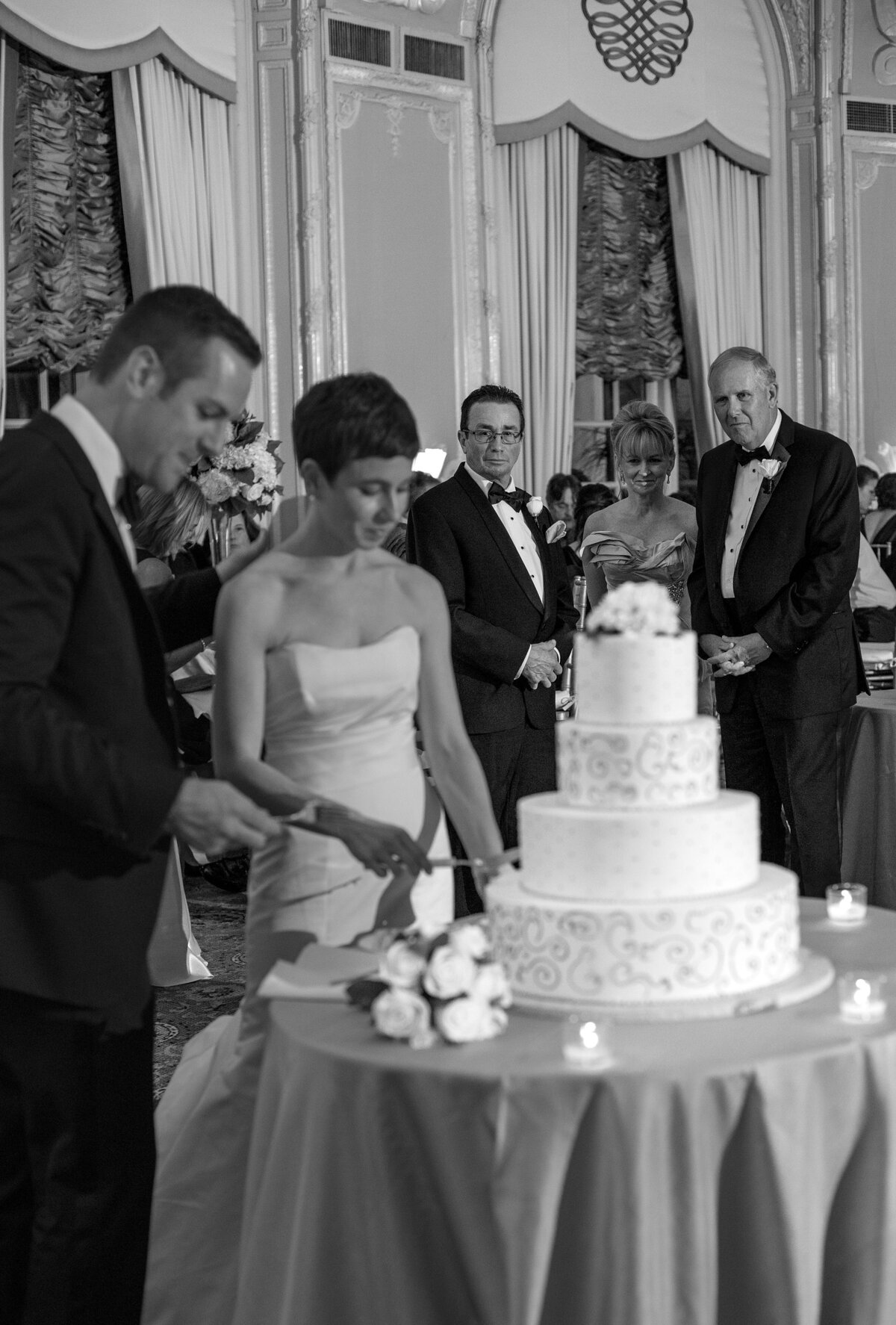 Bride and Groom cut wedding cake as parents watch during Fairmont Copley Plaza wedding reception.